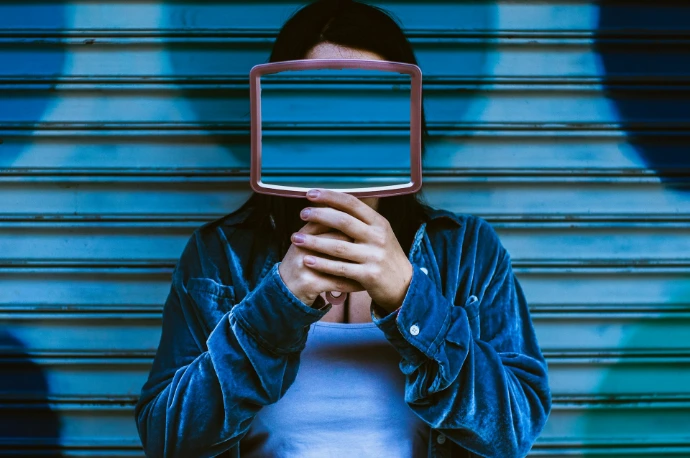 man covering face with mirror